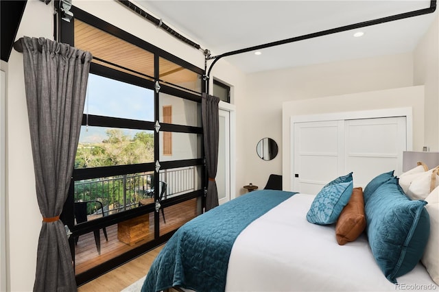 bedroom with access to outside, recessed lighting, and wood finished floors