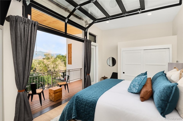 bedroom with access to exterior, recessed lighting, and light wood-type flooring