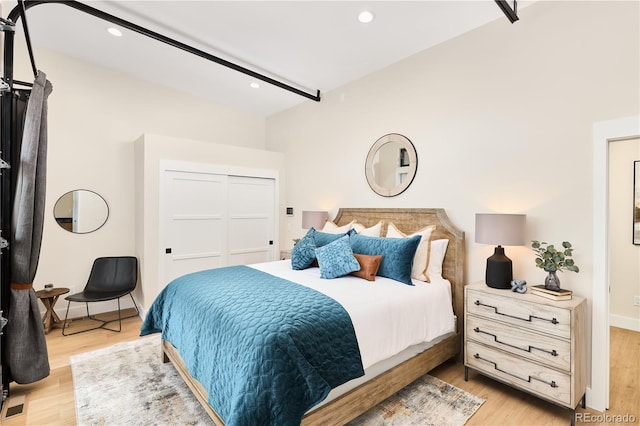 bedroom featuring light wood finished floors, recessed lighting, and a closet