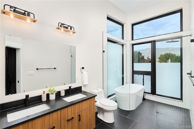 bathroom with tile patterned flooring, a soaking tub, double vanity, and a sink