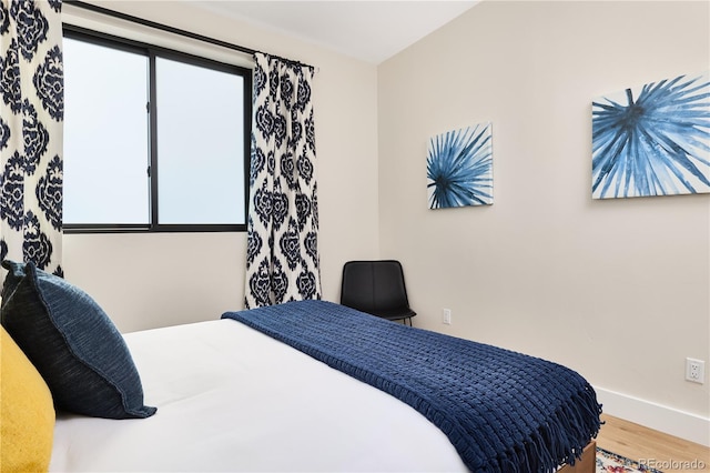 bedroom with baseboards and wood finished floors