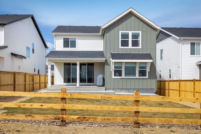 16568 W 92nd Pl, Arvada, CO 80007 - rear view of house with board and batten siding, a fenced front yard, and roof with shingles