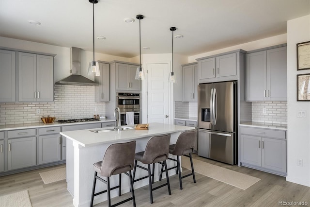 16568 W 92nd Pl, Arvada, CO 80007 - kitchen featuring stainless steel appliances, gray cabinetry, wall chimney range hood, and light wood-style floors