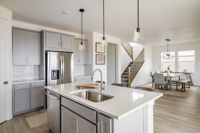 16568 W 92nd Pl, Arvada, CO 80007 - kitchen featuring stainless steel appliances, gray cabinets, light wood-type flooring, and backsplash