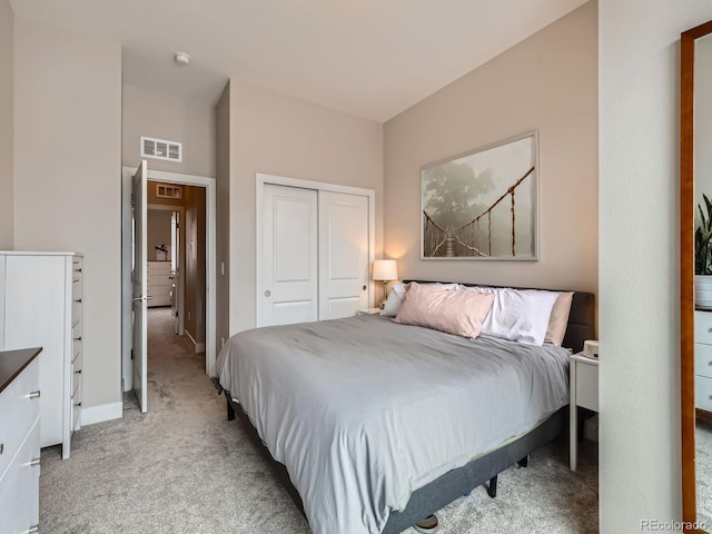 bedroom featuring light carpet, a closet, baseboards, and visible vents