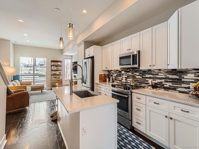 kitchen with light countertops, white cabinets, dark wood-type flooring, decorative backsplash, and stainless steel appliances