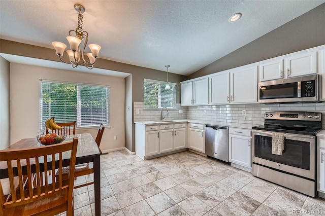 5534 S Wenatchee St, Aurora, CO 80015 - kitchen with stainless steel appliances, light countertops, decorative backsplash, white cabinets, and vaulted ceiling