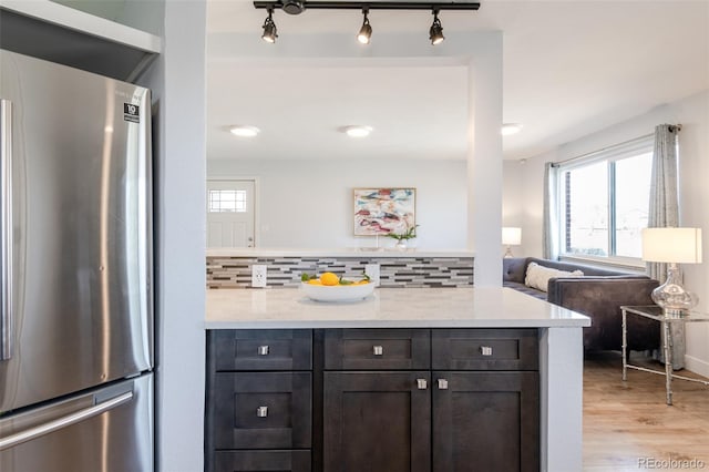 1476 W Dakota Ave, Denver, CO 80223 - kitchen featuring freestanding refrigerator, plenty of natural light, light wood finished floors, and tasteful backsplash