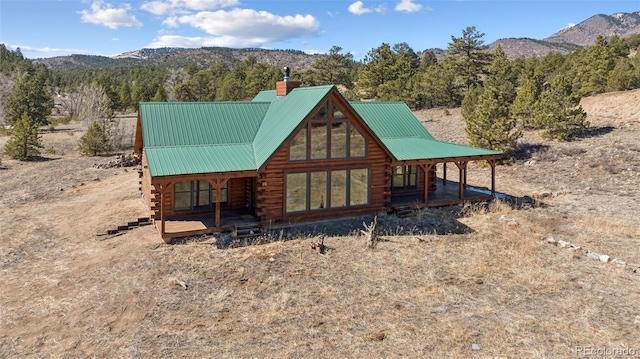 2555 New Mill Gulch Rd, Canon City, CO 81212 - view of front of home with log exterior, a chimney, a mountain view, and a porch