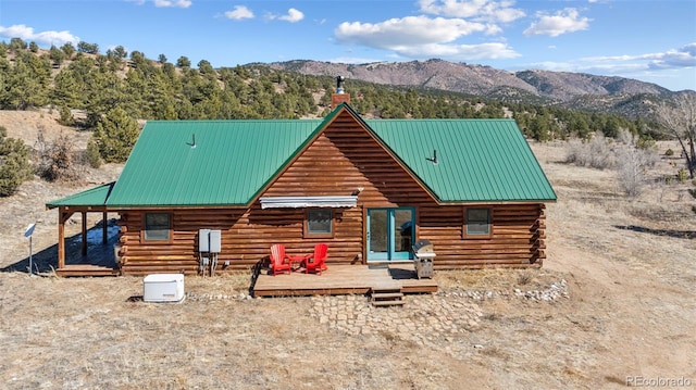 2555 New Mill Gulch Rd, Canon City, CO 81212 - view of front of property with a deck with mountain view, a chimney, log siding, and metal roof