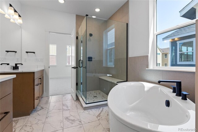 5621 W 141st Ln, Broomfield, CO 80020 - bathroom with vanity, a soaking tub, a stall shower, marble look tile flooring, and recessed lighting