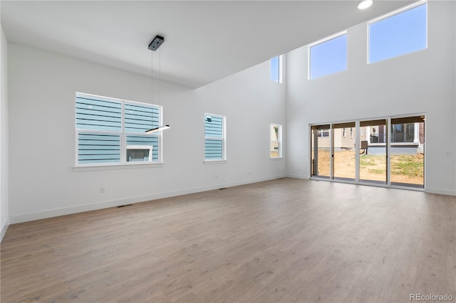 5621 W 141st Ln, Broomfield, CO 80020 - empty room featuring healthy amount of natural light, wood finished floors, and a towering ceiling