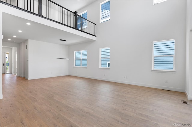 5621 W 141st Ln, Broomfield, CO 80020 - unfurnished living room featuring a high ceiling, light wood-style floors, plenty of natural light, and recessed lighting