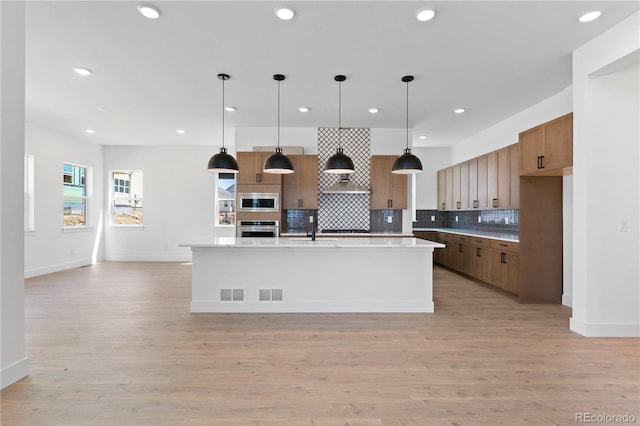 5621 W 141st Ln, Broomfield, CO 80020 - kitchen featuring appliances with stainless steel finishes, tasteful backsplash, recessed lighting, brown cabinetry, and exhaust hood