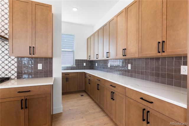 5621 W 141st Ln, Broomfield, CO 80020 - kitchen with light wood-type flooring, light countertops, tasteful backsplash, brown cabinets, and recessed lighting