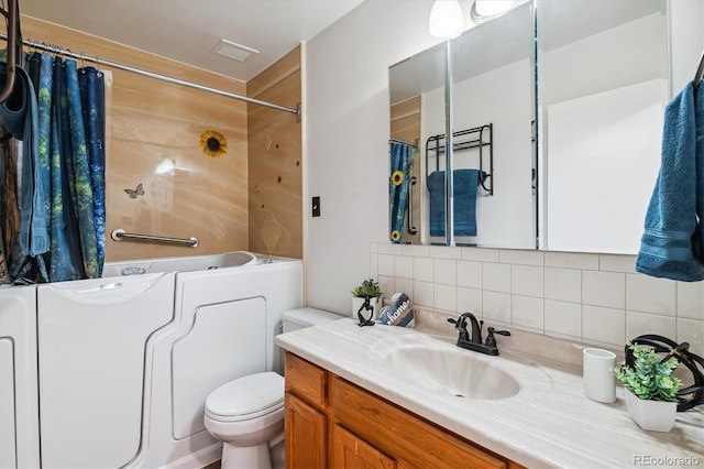 full bathroom with vanity, backsplash, toilet, and visible vents