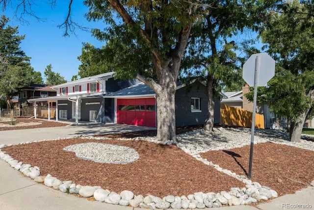 view of front of property with an attached garage, driveway, and fence