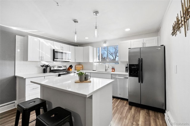 kitchen featuring a sink, decorative backsplash, appliances with stainless steel finishes, and white cabinets