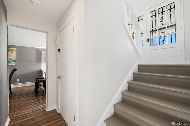 stairway featuring baseboards and wood finished floors