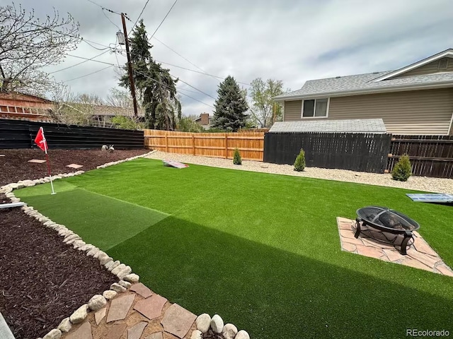 view of yard with a fire pit and a fenced backyard