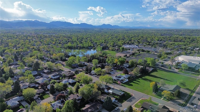 drone / aerial view featuring a view of trees and a water and mountain view