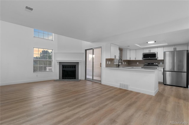 12635 E Pacific Cir Unit A, Aurora, CO 80014 - kitchen featuring appliances with stainless steel finishes, light countertops, light wood-style flooring, white cabinets, and baseboards