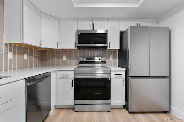 12635 E Pacific Cir Unit A, Aurora, CO 80014 - kitchen featuring stainless steel appliances, light countertops, white cabinetry, and light wood finished floors