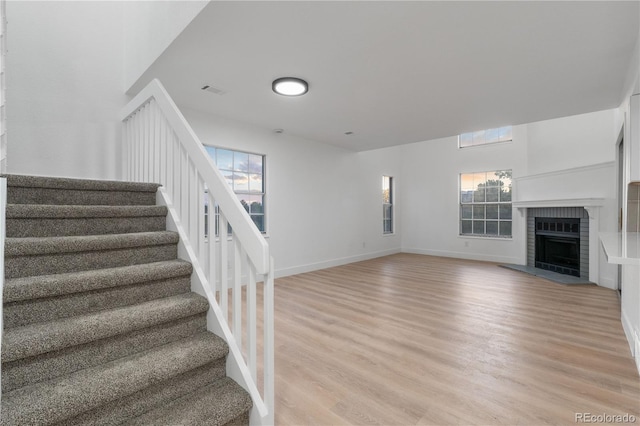 12635 E Pacific Cir Unit A, Aurora, CO 80014 - stairs with wood finished floors, a brick fireplace, and baseboards