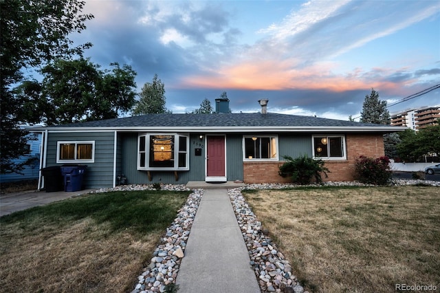 single story home with a lawn