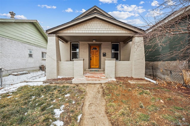 view of front of house with brick siding and fence