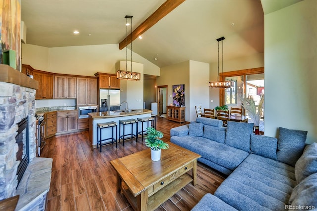 living room with a notable chandelier, beam ceiling, a fireplace, and dark hardwood / wood-style flooring