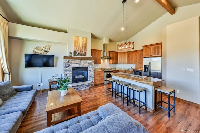 living room with sink, beam ceiling, dark wood-type flooring, a notable chandelier, and a fireplace