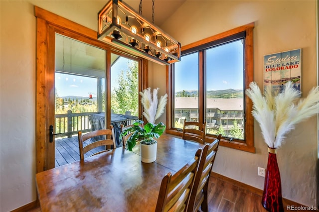 dining room featuring vaulted ceiling, dark wood-type flooring, and a notable chandelier