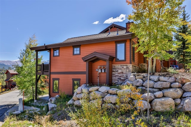 view of front of property with a balcony and a mountain view