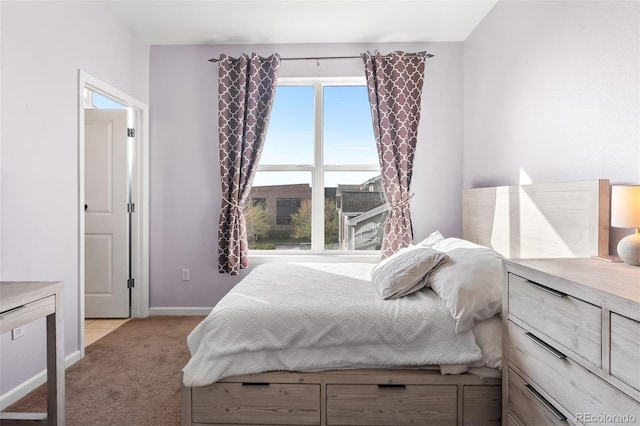 bedroom with baseboards and light colored carpet