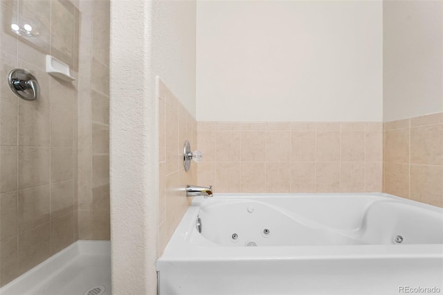 bathroom with a jetted tub and a shower stall