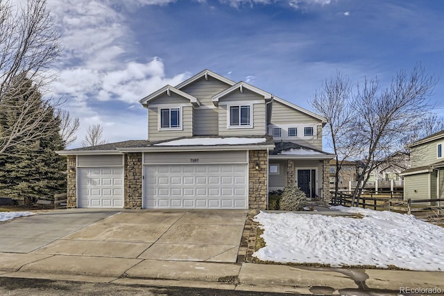 view of front of property with driveway, stone siding, and fence