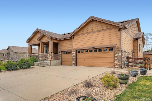 23993 E Briarwood Dr, Aurora, CO 80016 - craftsman-style house with stone siding, driveway, a porch, and a garage