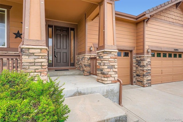 23993 E Briarwood Dr, Aurora, CO 80016 - entrance to property featuring stone siding, a garage, and covered porch