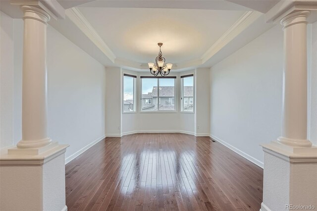23993 E Briarwood Dr, Aurora, CO 80016 - empty room with ornate columns, a tray ceiling, dark wood finished floors, and ornamental molding
