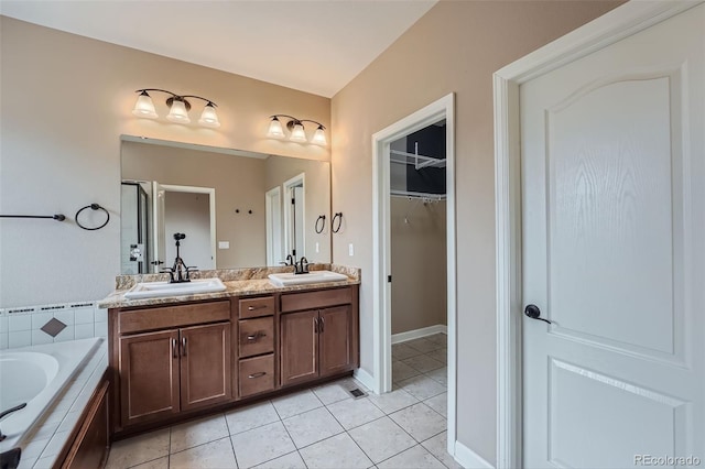 23993 E Briarwood Dr, Aurora, CO 80016 - full bathroom featuring tile patterned floors, double vanity, a walk in closet, tiled bath, and a shower
