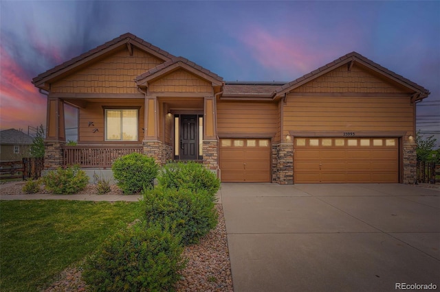 23993 E Briarwood Dr, Aurora, CO 80016 - craftsman house featuring concrete driveway, stone siding, a porch, a front lawn, and an attached garage