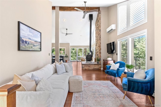 living room with a wall mounted AC, ceiling fan, a wood stove, a high ceiling, and dark hardwood / wood-style floors