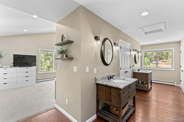 bathroom featuring a baseboard heating unit, plenty of natural light, and hardwood / wood-style floors