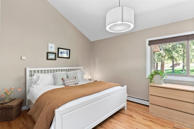 bedroom featuring baseboard heating, lofted ceiling, and light wood-type flooring