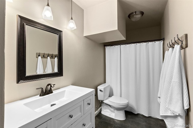 bathroom with toilet, vanity, and tile patterned floors