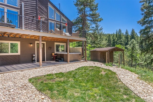 view of yard featuring a storage shed, a hot tub, and a deck