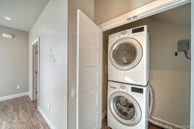 washroom featuring wood-type flooring and stacked washer and dryer