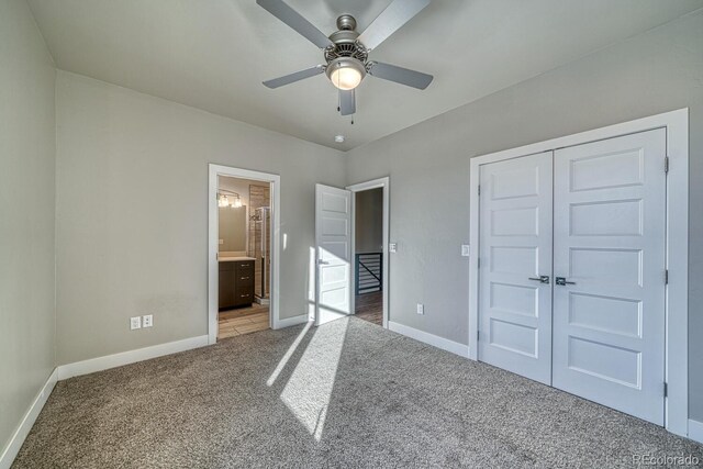 unfurnished bedroom with ensuite bathroom, a closet, ceiling fan, and carpet floors