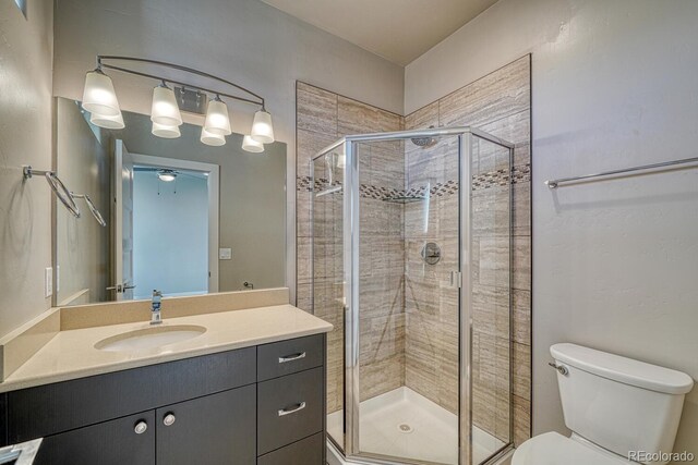 bathroom with toilet, walk in shower, and vanity